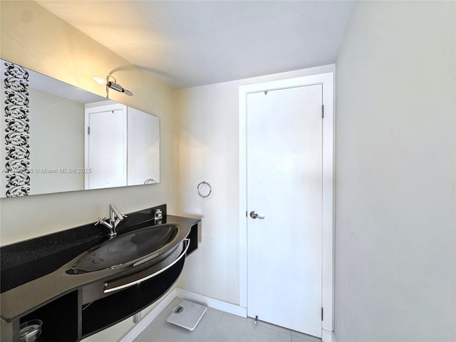 bathroom with baseboards, vanity, and tile patterned flooring