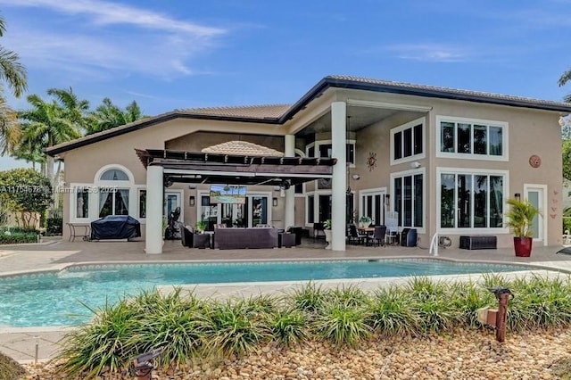 rear view of property featuring stucco siding, an outdoor pool, an outdoor hangout area, and a patio