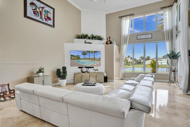 living area featuring marble finish floor, baseboards, a towering ceiling, and ornamental molding