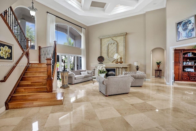 living room with stairs, a premium fireplace, a towering ceiling, arched walkways, and marble finish floor