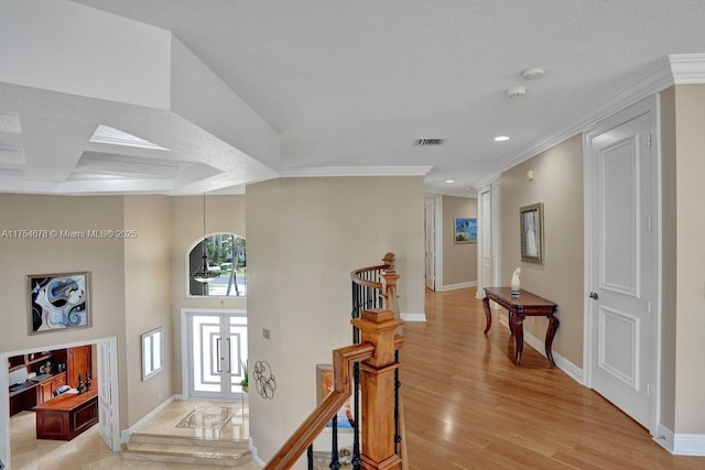 foyer entrance with visible vents, baseboards, ornamental molding, stairs, and light wood-style floors