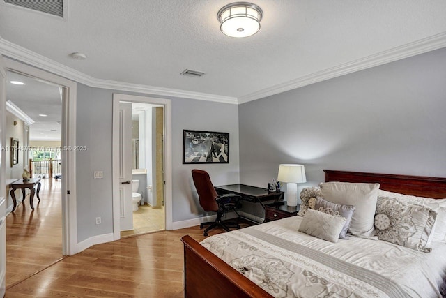 bedroom featuring visible vents, a textured ceiling, wood finished floors, and crown molding