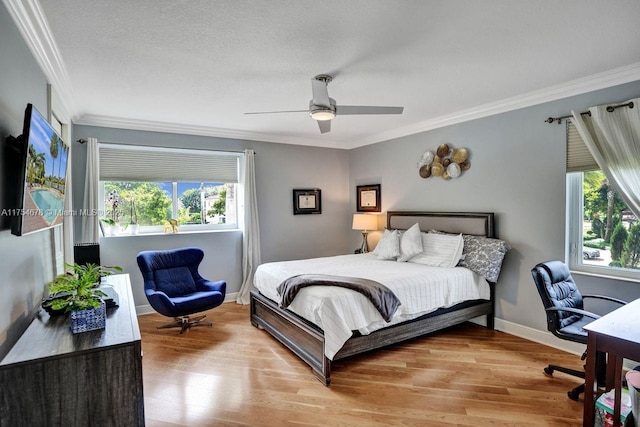 bedroom with baseboards, light wood-style floors, ceiling fan, and crown molding