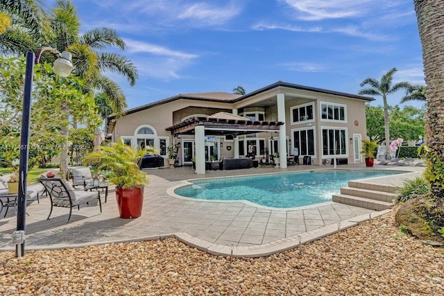 back of house with stucco siding, an outdoor pool, and a patio