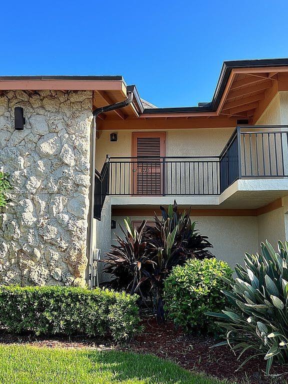 view of side of home with stucco siding and a balcony