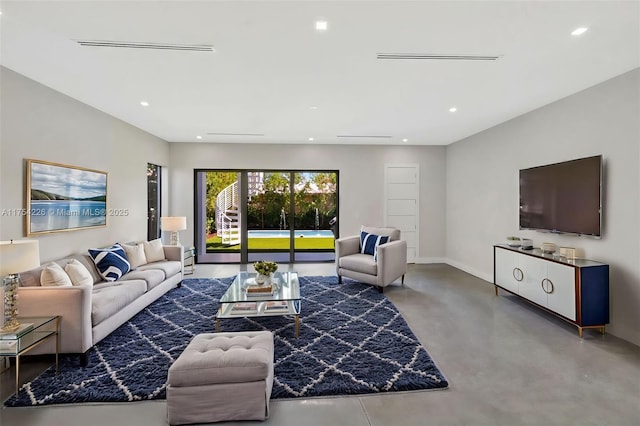 living room with finished concrete floors, recessed lighting, and baseboards