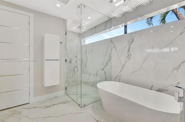 full bath with a marble finish shower, recessed lighting, a freestanding tub, marble finish floor, and stone wall