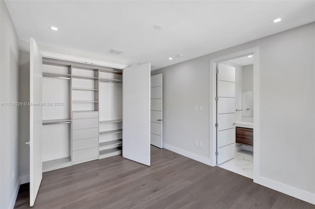 unfurnished bedroom with a closet, recessed lighting, baseboards, and wood finished floors