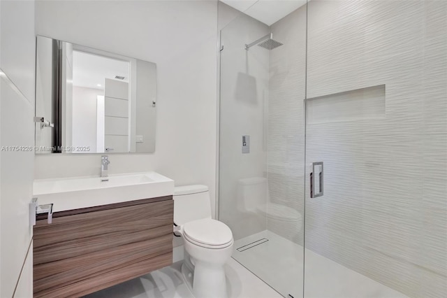 bathroom featuring a shower with shower door, toilet, and vanity