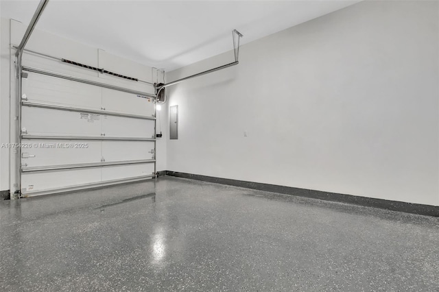 garage featuring electric panel and baseboards