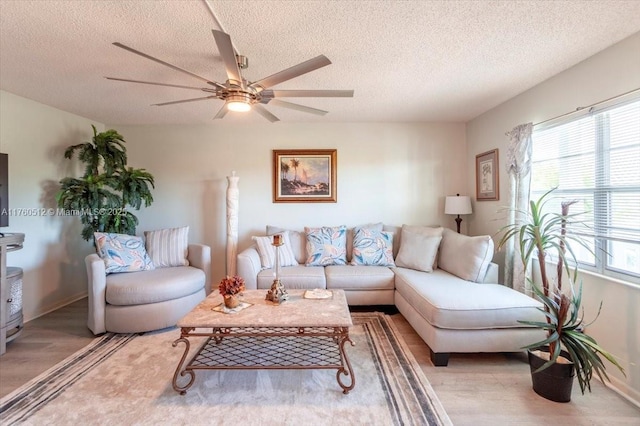 living room featuring ceiling fan, plenty of natural light, and light wood-style flooring