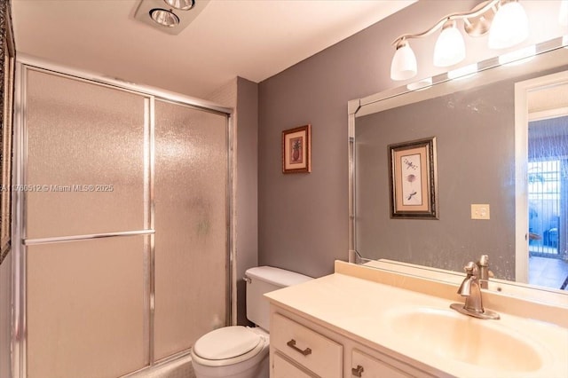 bathroom featuring vanity, toilet, and a stall shower