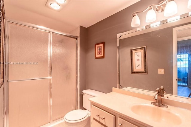 full bathroom with a shower stall, vanity, and toilet