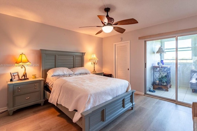 bedroom featuring access to exterior, light wood finished floors, baseboards, and a closet