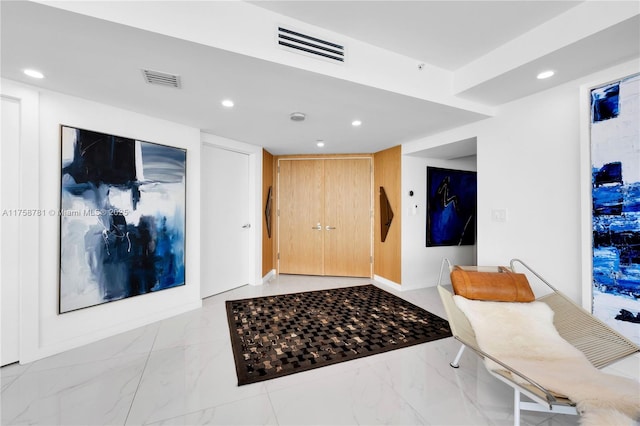 foyer entrance with recessed lighting and marble finish floor