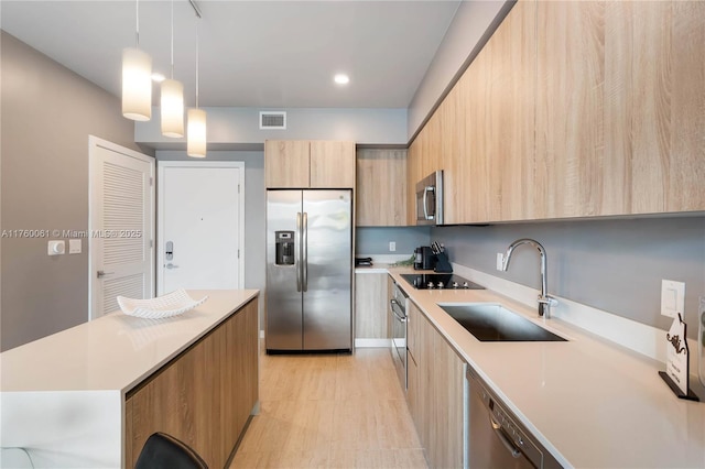 kitchen with a sink, stainless steel appliances, modern cabinets, and visible vents