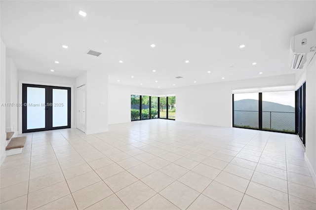 interior space with light tile patterned flooring, visible vents, recessed lighting, and a wall unit AC