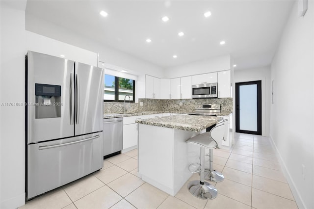 kitchen featuring white cabinetry, light tile patterned floors, backsplash, and stainless steel appliances