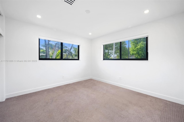 empty room featuring recessed lighting, visible vents, baseboards, and carpet