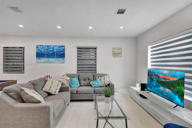 living area featuring light tile patterned floors, visible vents, baseboards, and recessed lighting