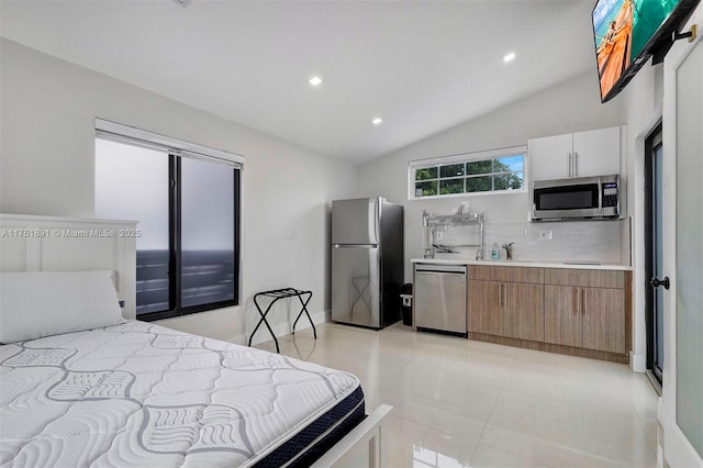 bedroom featuring a sink, freestanding refrigerator, recessed lighting, light tile patterned floors, and vaulted ceiling