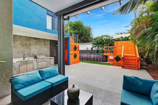 view of patio with fence, an outdoor kitchen, area for grilling, outdoor lounge area, and a playground