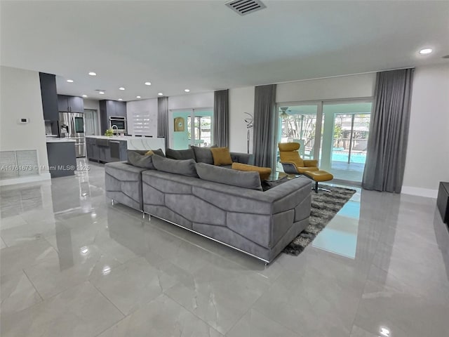 living room with recessed lighting, visible vents, and baseboards