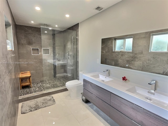 bathroom featuring visible vents, a shower stall, toilet, and a sink