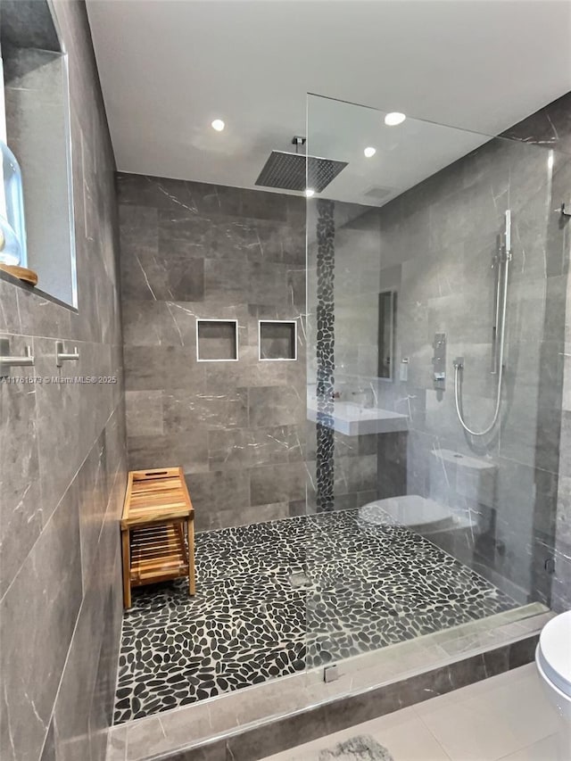 full bath featuring tile patterned flooring, recessed lighting, and a tile shower