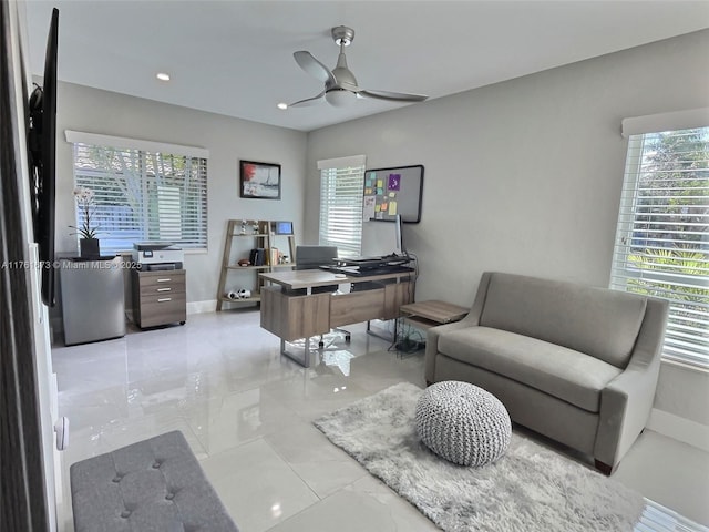 office area featuring baseboards, marble finish floor, a healthy amount of sunlight, and a ceiling fan