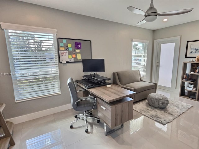 office space with baseboards, ceiling fan, and tile patterned flooring