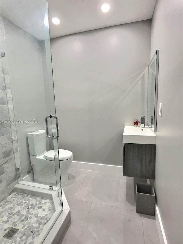 bathroom featuring baseboards, vanity, and a shower stall