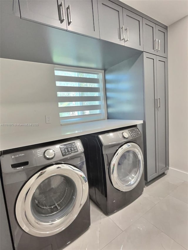 clothes washing area with cabinet space and separate washer and dryer