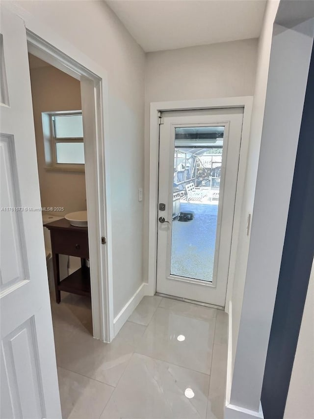 entryway with light tile patterned floors and baseboards