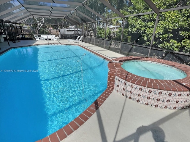 outdoor pool with a lanai, an in ground hot tub, and a patio