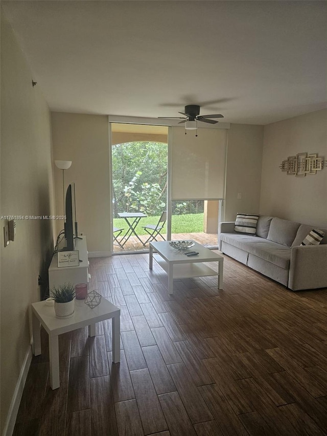 unfurnished living room with ceiling fan, wood finished floors, baseboards, and expansive windows