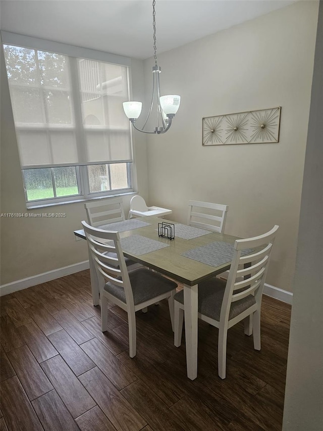 dining room with a chandelier, baseboards, and wood finished floors