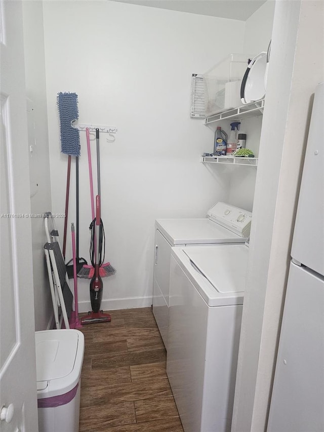 laundry room featuring wood finished floors, separate washer and dryer, baseboards, and laundry area