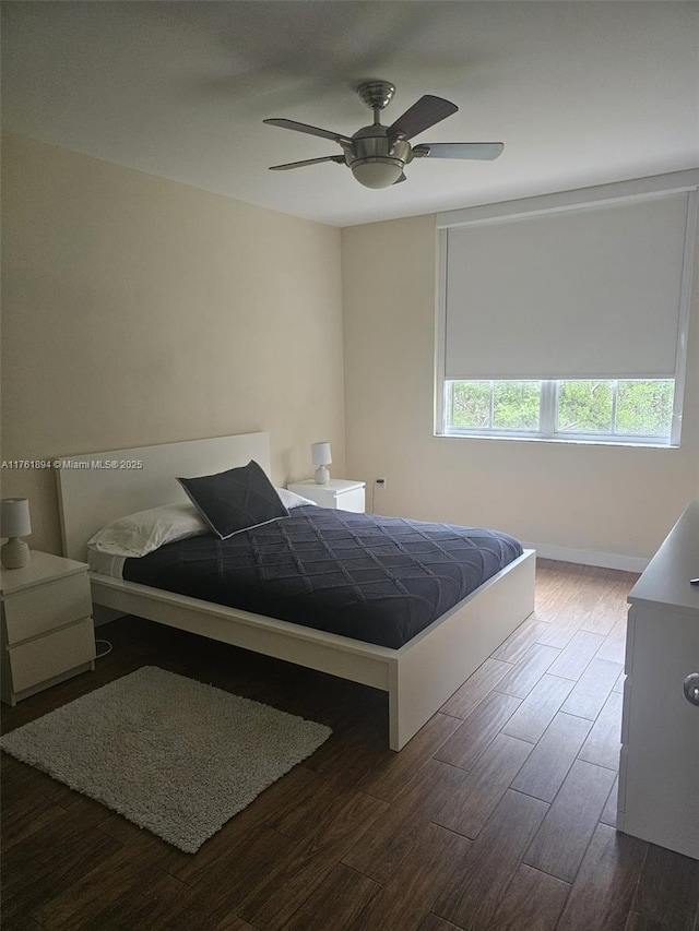 bedroom featuring ceiling fan, baseboards, and dark wood-style floors