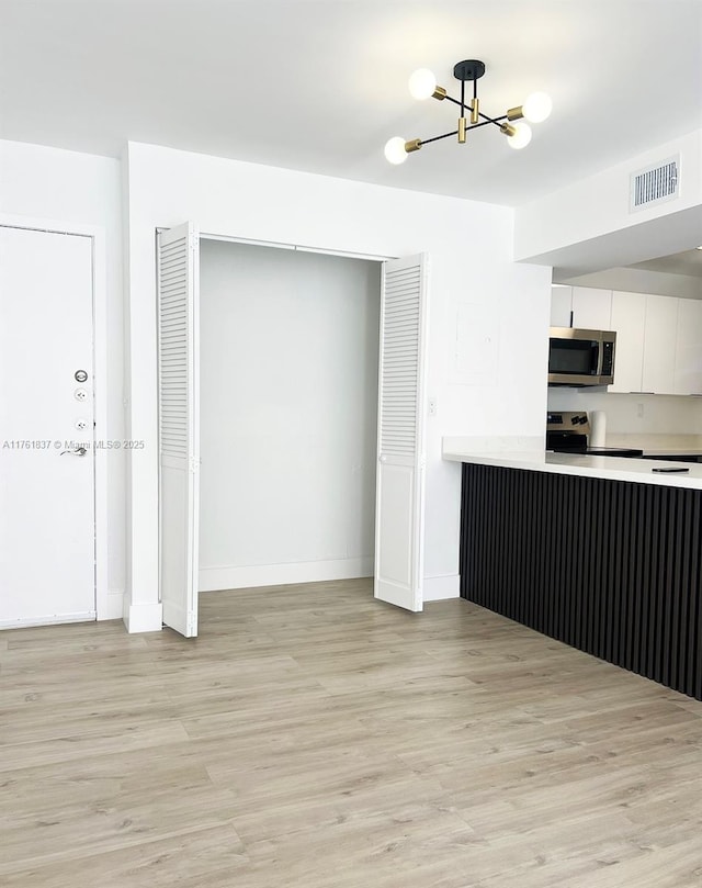 kitchen with white cabinetry, light countertops, visible vents, and appliances with stainless steel finishes