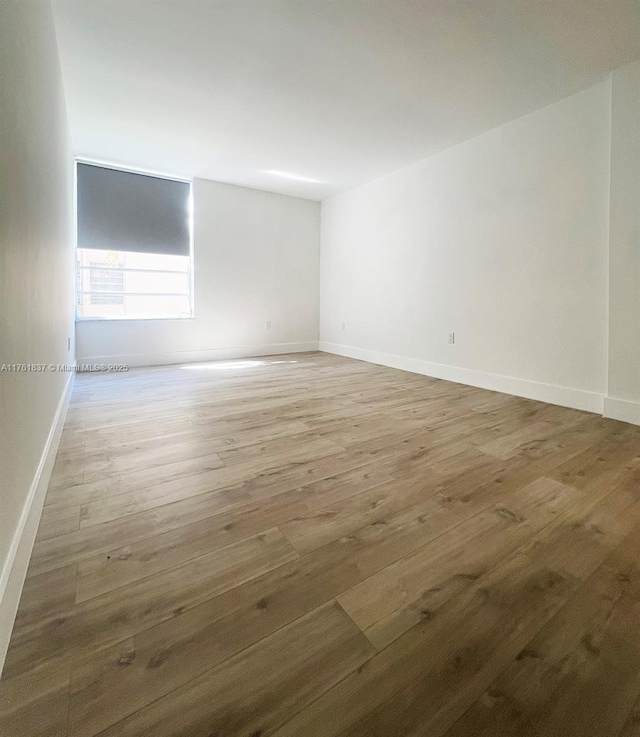 unfurnished room with baseboards and wood finished floors