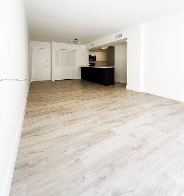 unfurnished living room featuring visible vents and light wood finished floors