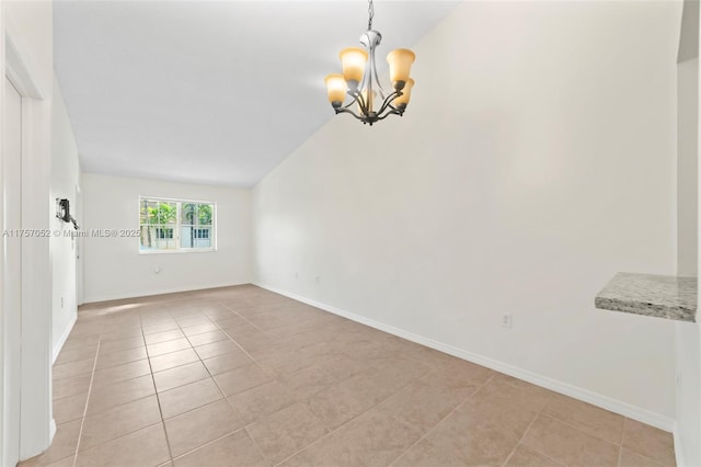 spare room with an inviting chandelier, light tile patterned flooring, baseboards, and lofted ceiling