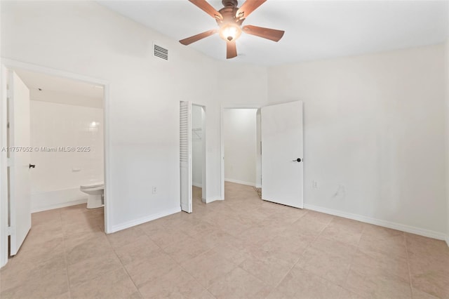 unfurnished bedroom with baseboards, visible vents, a closet, ensuite bathroom, and a walk in closet