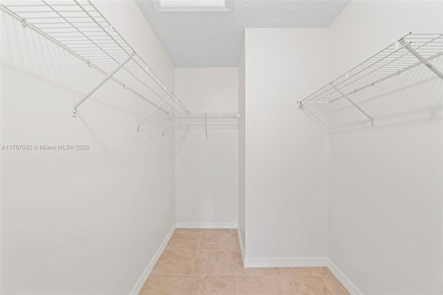 spacious closet with light tile patterned floors