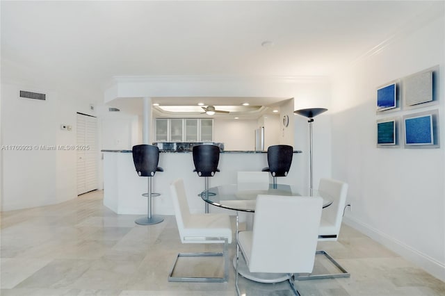 dining room featuring crown molding, baseboards, visible vents, and ceiling fan