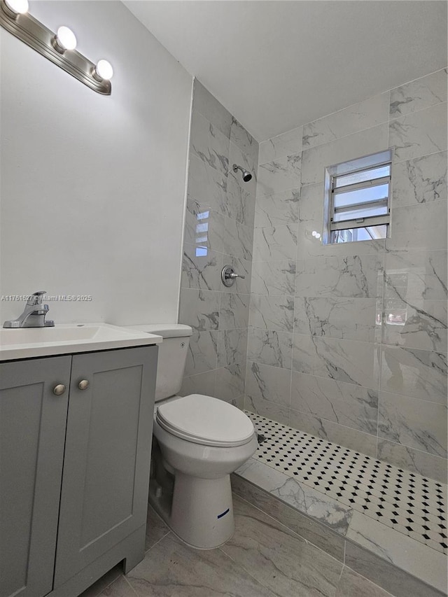 full bath with vanity, toilet, marble finish floor, and a marble finish shower