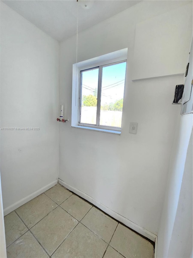 spare room with light tile patterned floors and baseboards