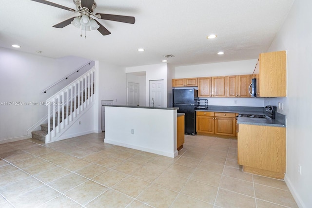 kitchen with recessed lighting, gas range, dark countertops, and freestanding refrigerator