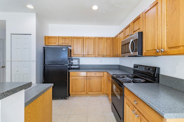 kitchen with light tile patterned floors, brown cabinetry, recessed lighting, black appliances, and a textured ceiling